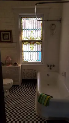 a bathroom with a tub and a stained glass window at Weehawken on Hudson in Union City