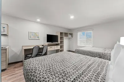 a bedroom with a bed and a desk with a computer at WoodSpring Suites Wilmington Riverfront in Wilmington