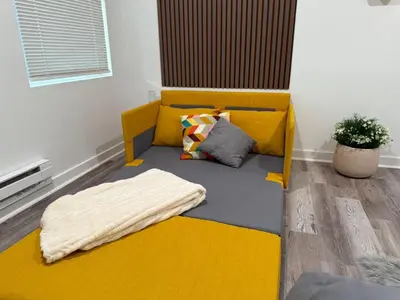 a yellow couch with a blanket on it in a room at Cómodo departamento en Elizabeth cerca de NYC in Elizabeth