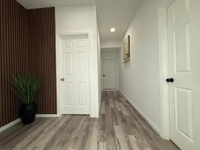 a hallway with a white door and a potted plant at Cómodo departamento en Elizabeth cerca de NYC in Elizabeth