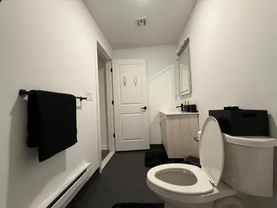 a white bathroom with a toilet and a sink at Cómodo departamento en Elizabeth cerca de NYC in Elizabeth