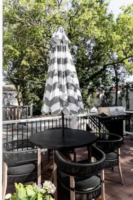 a table and chairs with an umbrella on a patio at Quiet close to NYC BBQ Deck in Jersey City
