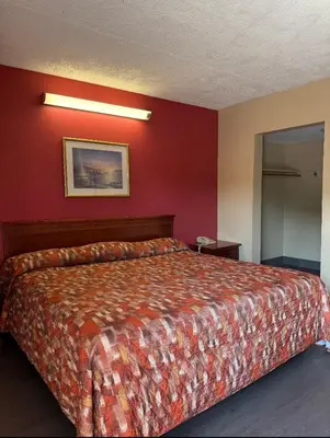 a bedroom with a bed with a red wall at Linden Motor Inn in Linden