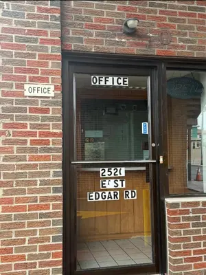 an office sign on the door of a brick building at Linden Motor Inn in Linden
