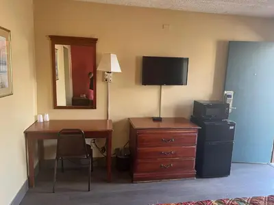 a room with a desk and a television and a desk with a computer at Linden Motor Inn in Linden