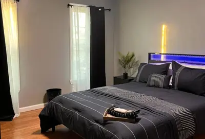a bedroom with a large bed with a blue headboard at Cozy Modern Home with Large Fenced in Backyard in Camden