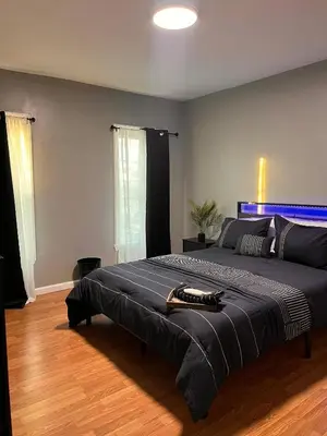 a bedroom with a large bed with a blue headboard at Cozy Modern Home with Large Fenced in Backyard in Camden