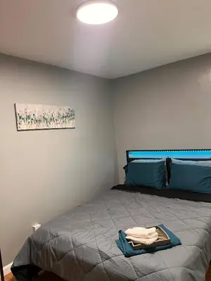 a bedroom with a bed and a painting on the wall at Cozy Modern Home with Large Fenced in Backyard in Camden