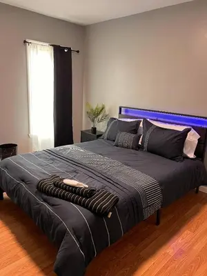 a large bed with a blue headboard in a bedroom at Cozy Modern Home with Large Fenced in Backyard in Camden