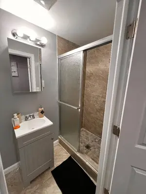 a bathroom with a shower and a sink at Cozy Modern Home with Large Fenced in Backyard in Camden
