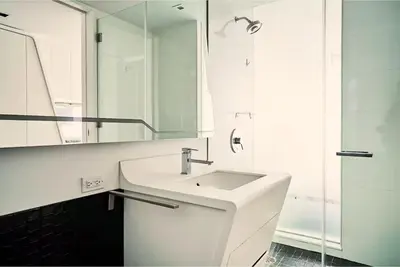 a white bathroom with a sink and a mirror at W residence in New York