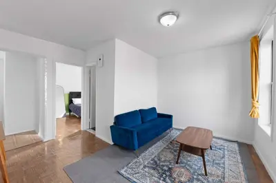 a living room with a blue chair and a table at NY-11-7 Cozy 1BR 1BATH In East Village in New York