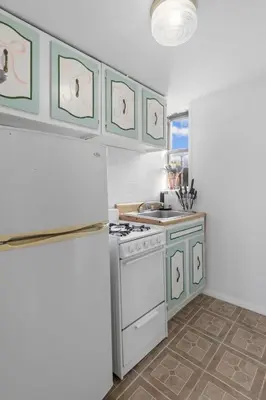 a kitchen with green cabinets and a white refrigerator at NY-11-7 Cozy 1BR 1BATH In East Village in New York