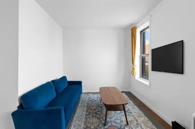 a living room with a blue couch and a table at NY-11-7 Cozy 1BR 1BATH In East Village in New York