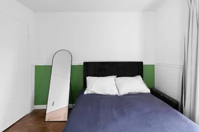 a bedroom with a bed with a mirror next to it at NY-11-7 Cozy 1BR 1BATH In East Village in New York