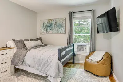 a bedroom with a bed and a tv and a window at Boat, Fish and Unwind Waterfront Gem in Pocono Mtns in Lake Ariel
