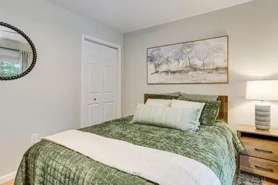a bedroom with a bed with a green comforter at Boat, Fish and Unwind Waterfront Gem in Pocono Mtns in Lake Ariel