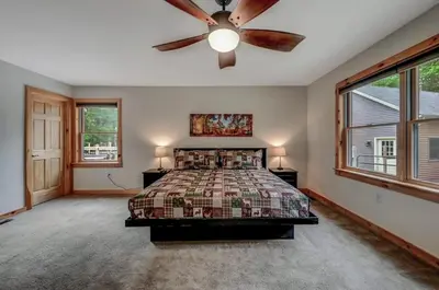 a bedroom with a bed and a ceiling fan at Tree Haven- fenced yard, hot tub, fire pit in Hawley