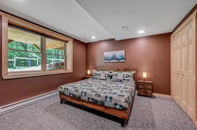 a bedroom with a bed and a window at Tree Haven- fenced yard, hot tub, fire pit in Hawley