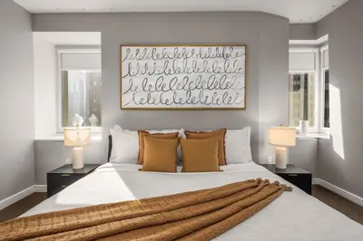 a bedroom with a large white bed with two lamps at Chic NYC Retreat Beside Broadway & Iconic Sights in New York