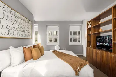 a bedroom with a white bed and a tv at Chic NYC Retreat Beside Broadway & Iconic Sights in New York