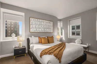 a bedroom with a large bed and two windows at Chic NYC Retreat Beside Broadway & Iconic Sights in New York