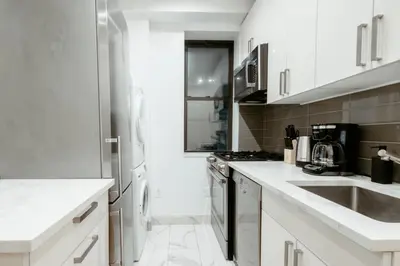 a white kitchen with a sink and a stove at 3BD 2BA in Upper West Side Manhattan! 5 Star Location in New York