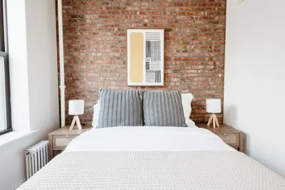 a bedroom with a brick wall and a bed at 3BD 2BA in Upper West Side Manhattan! 5 Star Location in New York