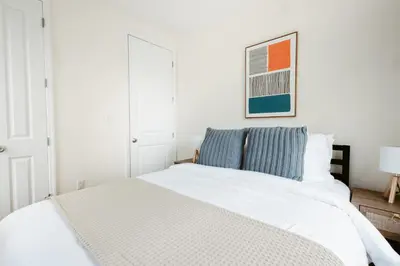 a bedroom with a white bed and a picture on the wall at 3BD 2BA in Upper West Side Manhattan! 5 Star Location in New York