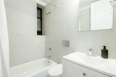 a white bathroom with a sink and a toilet at 3BD 2BA in Upper West Side Manhattan! 5 Star Location in New York