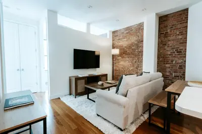 a living room with a couch and a tv at 3BD 2BA in Upper West Side Manhattan! 5 Star Location in New York