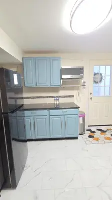 a kitchen with blue cabinets and a refrigerator at Staten Island Cozy Private 1-br Basement Apt close to NYC Family & Pet Friendly in Willowbrook