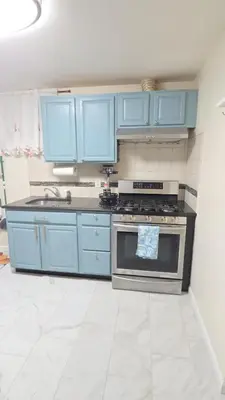 a kitchen with blue cabinets and a stove at Staten Island Cozy Private 1-br Basement Apt close to NYC Family & Pet Friendly in Willowbrook