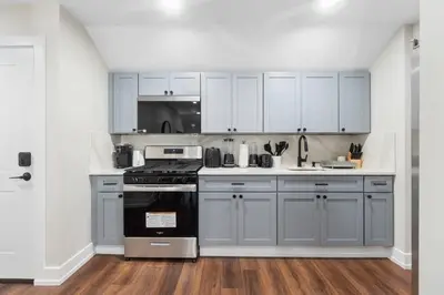 a kitchen with white cabinets and a stove at Family Suite - Free Parking - Near NYC & Shops at Main Street in North Bergen