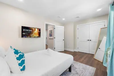 a bedroom with a white bed and a white couch at Family Suite - Free Parking - Near NYC & Shops at Main Street in North Bergen