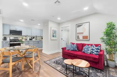 a living room with a red couch and a table at Family Suite - Free Parking - Near NYC & Shops at Main Street in North Bergen