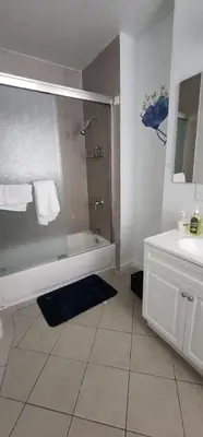 a bathroom with a shower and a tub and a sink at Massive 5 bedroom Close to NYC in Newark