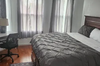 a bedroom with a bed and a desk and a chair at Massive 5 bedroom Close to NYC in Newark