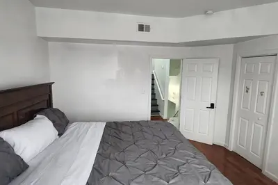 a bedroom with a large bed and a staircase at Massive 5 bedroom Close to NYC in Newark