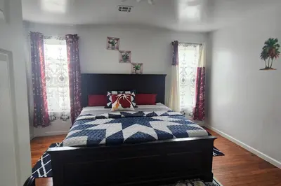 a bedroom with a bed with a blue and white comforter at Massive 5 bedroom Close to NYC in Newark