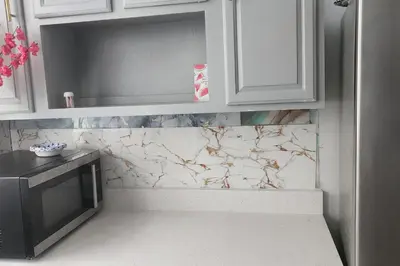 a kitchen with white cabinets and a marble counter top at Massive 5 bedroom Close to NYC in Newark