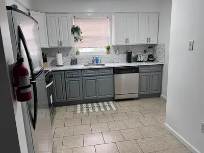 a kitchen with gray cabinets and a refrigerator at Exquisite Luxury 3KINGs Bed, 2 Bath in Newark