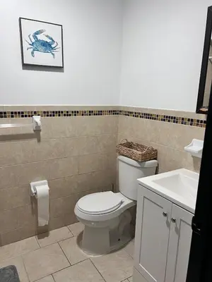 a bathroom with a white toilet and a sink at Exquisite Luxury 3KINGs Bed, 2 Bath in Newark