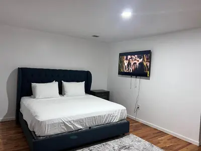 a bedroom with a bed and a picture on the wall at Exquisite Luxury 3KINGs Bed, 2 Bath in Newark