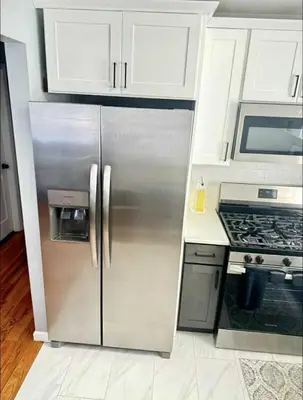 a kitchen with a stainless steel refrigerator and a stove at Cozy Rooms in a Modern and Beautiful Apartment in Irvington