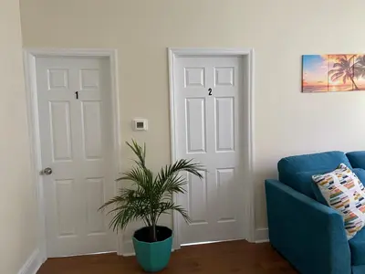a living room with a blue couch and a plant at Tropical Oasis - Room 1 in Irvington