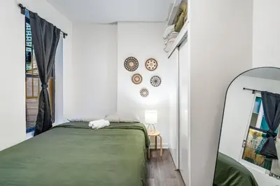 a bedroom with a green bed and a mirror at Apartment near Times Square Manhattan New York in New York