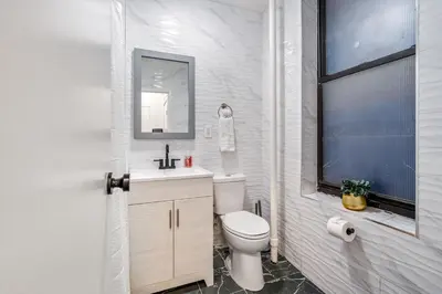 a white bathroom with a toilet and a sink at Apartment near Times Square Manhattan New York in New York