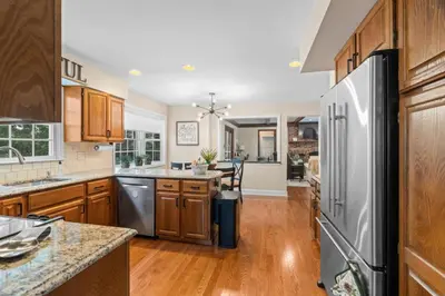 a kitchen with wooden cabinets and a stainless steel refrigerator at Pine Cove Retreat - 4BR - Pool