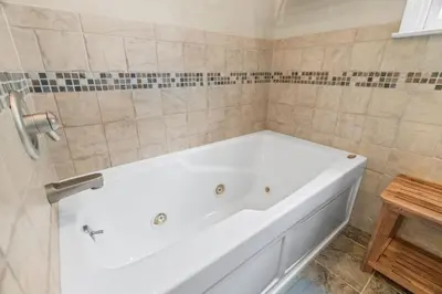 a white bath tub in a bathroom with tiles at Pine Cove Retreat - 4BR - Pool